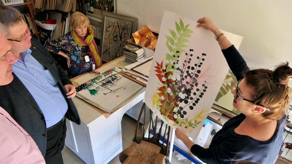 Die Tochter der Künstlerin, Rachel Horam, zeigt den Gästen einige der zuletzt entstandenen Siebdrucke aus der Werkstatt von Ruth Horam.